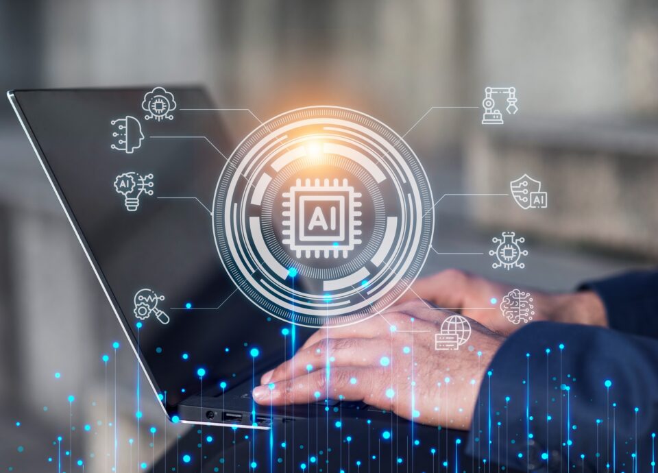 Mani che digitano su un computer portatile con un'illustrazione digitale della tecnologia AI sovrapposta, caratterizzata da un'icona centrale con un chip e simboli artificiali correlati.